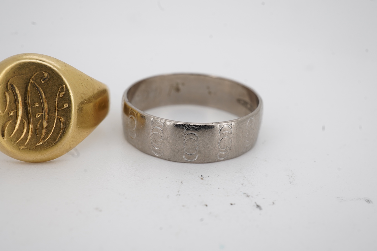 A 1990's 18ct gold wedding band, with engraved inscription, size U/V, a similar signet ring with engraved monogram and inscription, size I and an early 1970's 18ct white gold band, size O, gross weight 15.4 grams.